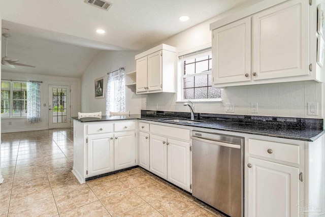 kitchen featuring vaulted ceiling, white cabinetry, stainless steel dishwasher, and sink