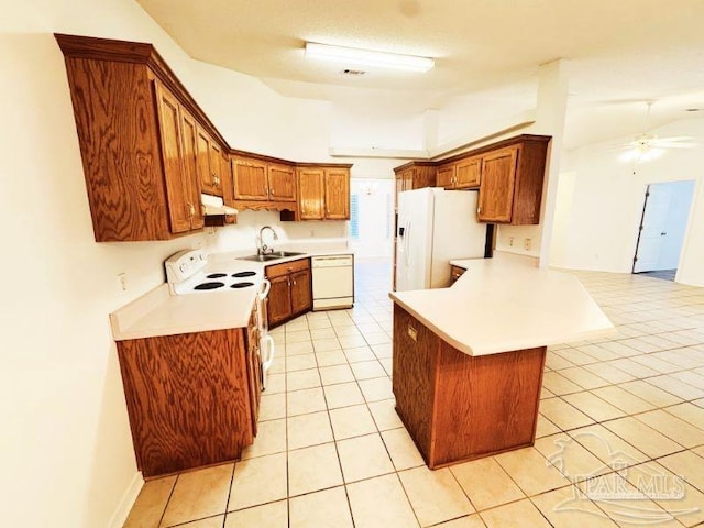 kitchen with white appliances, a breakfast bar area, kitchen peninsula, sink, and light tile patterned flooring