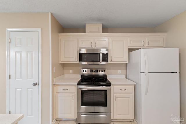 kitchen with a textured ceiling and stainless steel appliances