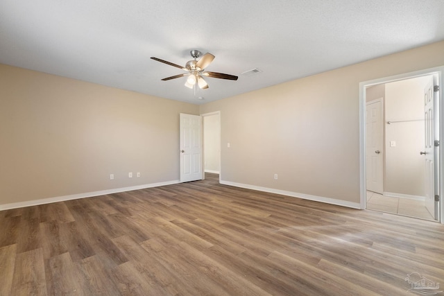 empty room featuring ceiling fan, a textured ceiling, and hardwood / wood-style floors