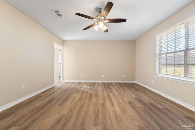 unfurnished room with hardwood / wood-style floors, a textured ceiling, and ceiling fan