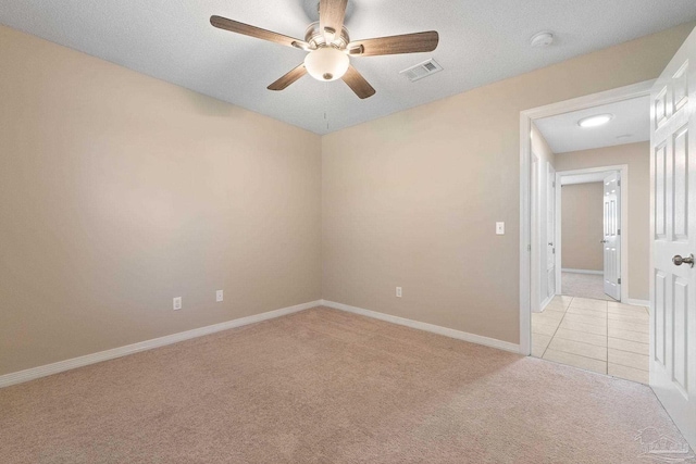 unfurnished room with a textured ceiling, light colored carpet, and ceiling fan