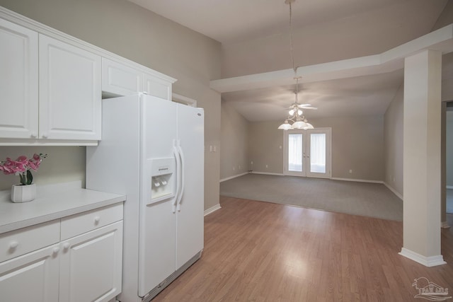 kitchen featuring light wood-style flooring, white cabinets, white refrigerator with ice dispenser, and light countertops