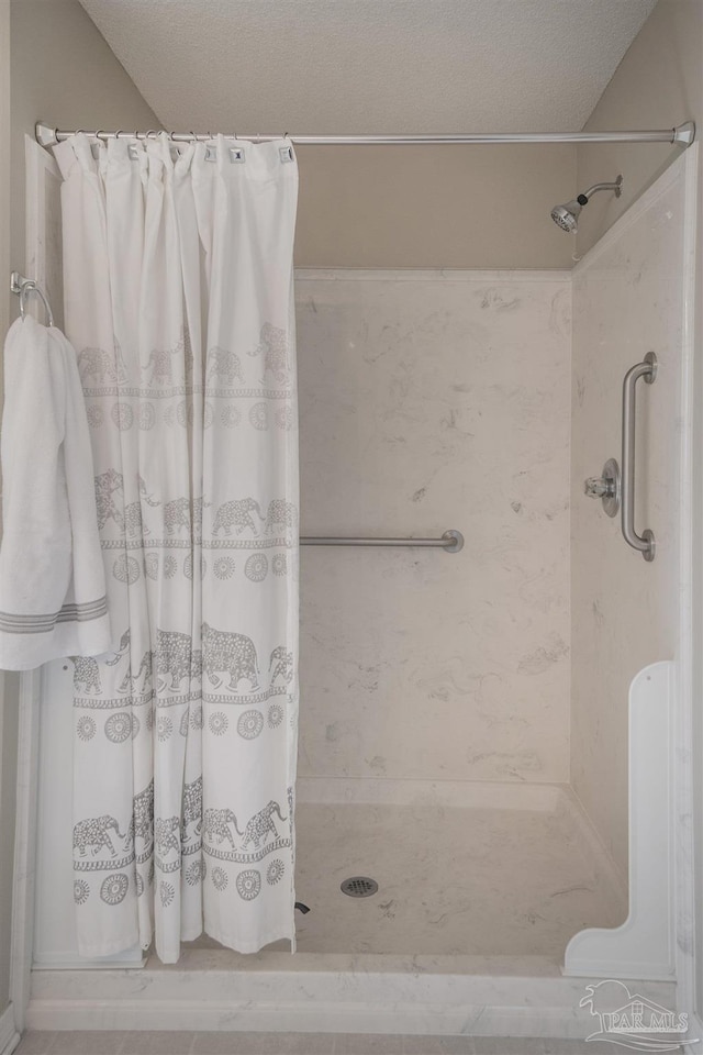 bathroom featuring a stall shower and a textured ceiling