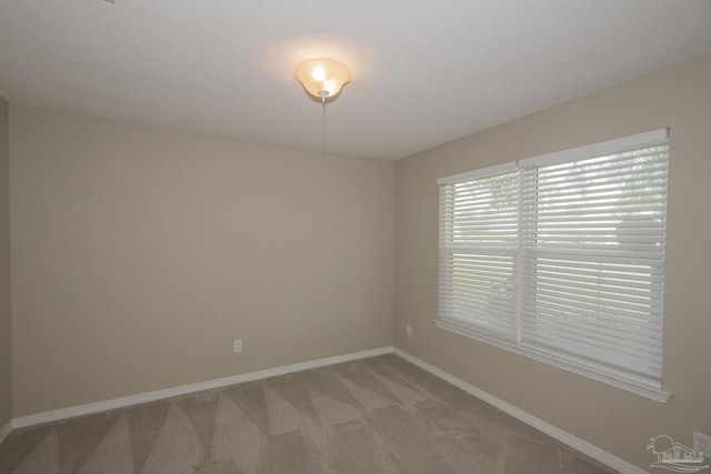 unfurnished room with light colored carpet and baseboards