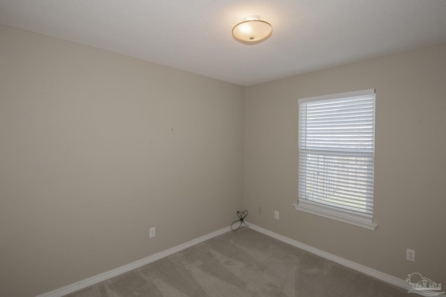 unfurnished room featuring light colored carpet and baseboards