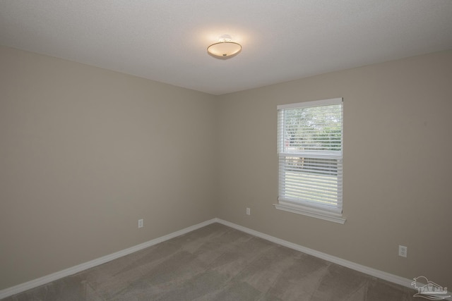 carpeted empty room with baseboards