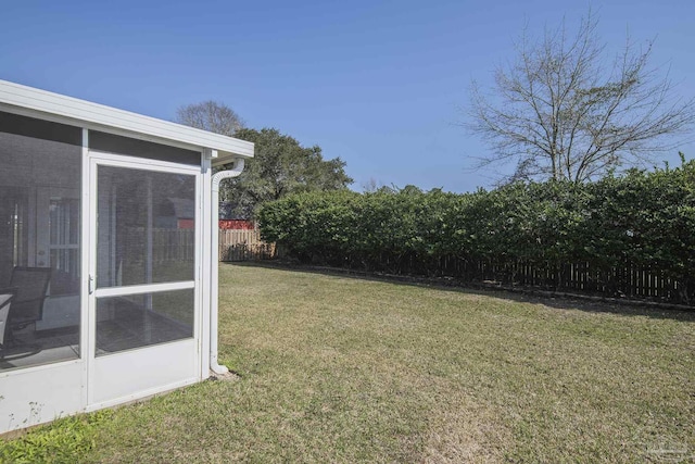 view of yard with fence and a sunroom