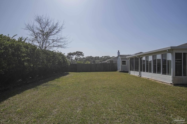 view of yard featuring a sunroom and fence