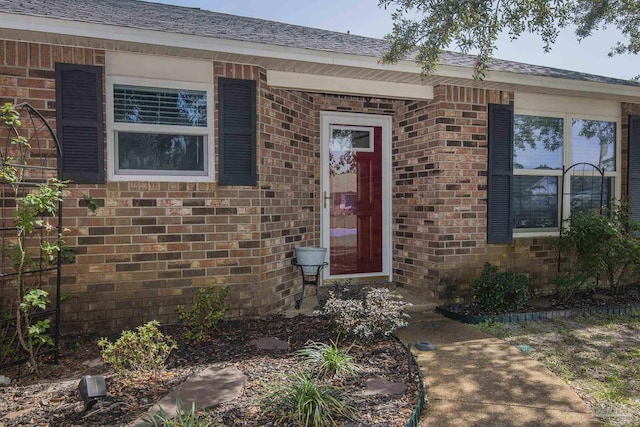 property entrance featuring brick siding