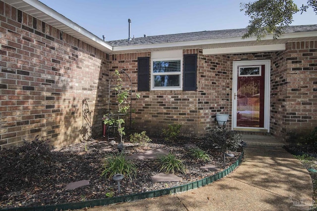 entrance to property featuring brick siding