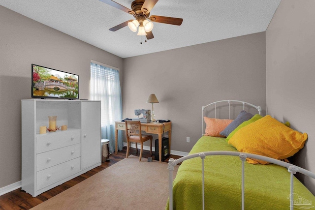 bedroom featuring ceiling fan, dark hardwood / wood-style floors, and a textured ceiling