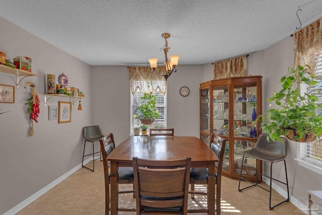 dining space featuring an inviting chandelier and a textured ceiling