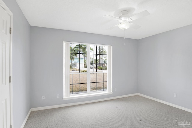 carpeted spare room with a wealth of natural light and ceiling fan