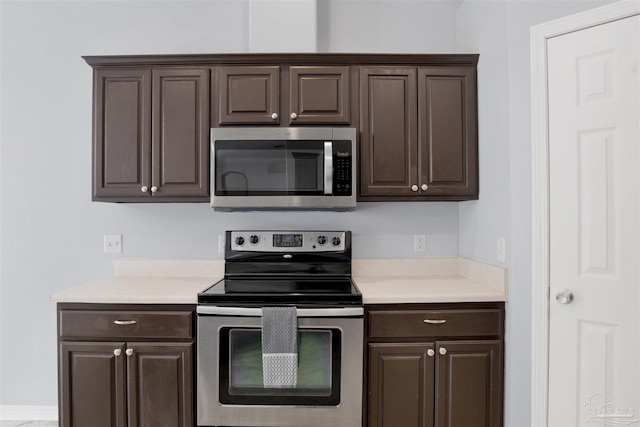 kitchen with appliances with stainless steel finishes and dark brown cabinets