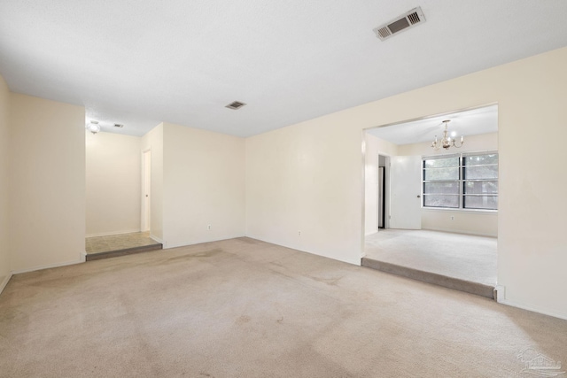 unfurnished room featuring a chandelier, carpet floors, and visible vents