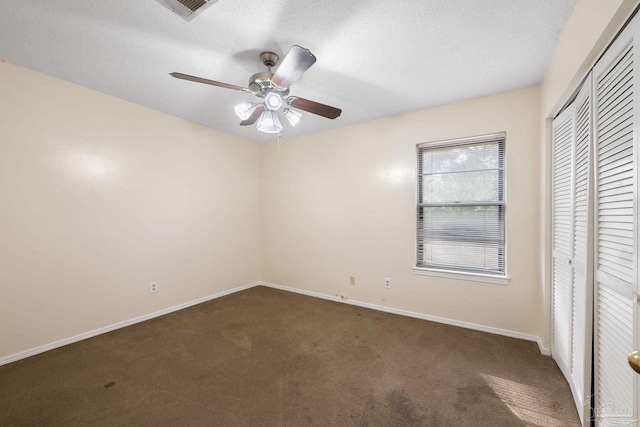 unfurnished bedroom featuring a textured ceiling, carpet floors, a closet, and baseboards