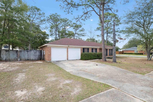 ranch-style house featuring an attached garage, fence, concrete driveway, and brick siding