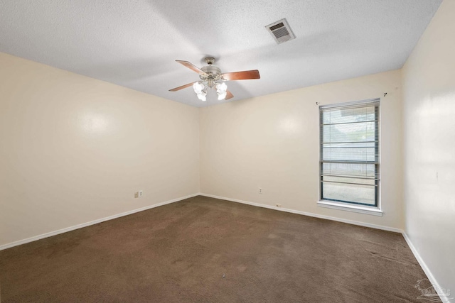 unfurnished room featuring a textured ceiling, a ceiling fan, visible vents, baseboards, and dark carpet