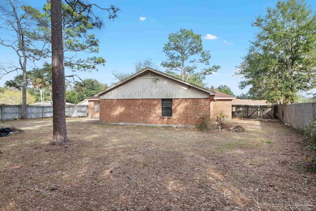 exterior space with brick siding and a fenced backyard