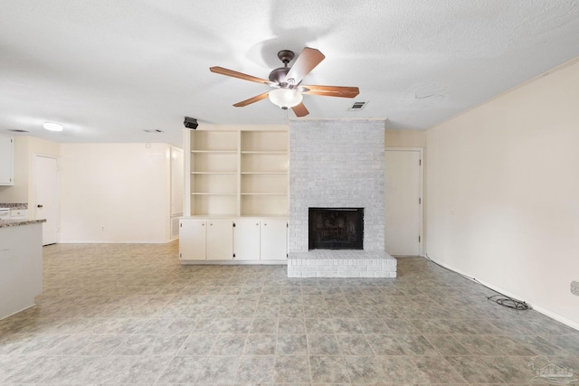 unfurnished living room with a textured ceiling, ceiling fan, a fireplace, visible vents, and built in features