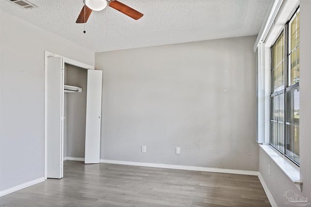 2811 Langley Ave Unit 221, Pensacola, FL 32504 - unfurnished bedroom featuring a textured ceiling, wood finished floors, a ceiling fan, and baseboards