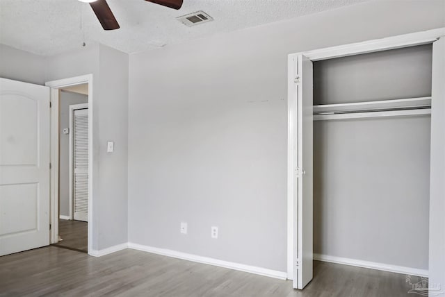 2811 Langley Ave Unit 221, Pensacola, FL 32504 - unfurnished bedroom featuring wood finished floors, baseboards, a closet, ceiling fan, and a textured ceiling