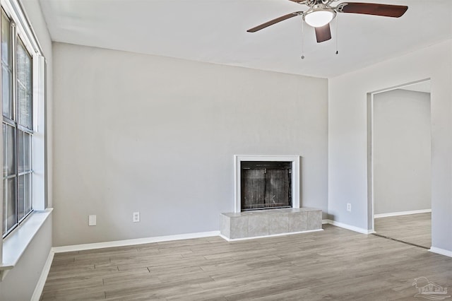 2811 Langley Ave Unit 221, Pensacola, FL 32504 - unfurnished living room with wood finished floors, ceiling fan, a tiled fireplace, and baseboards