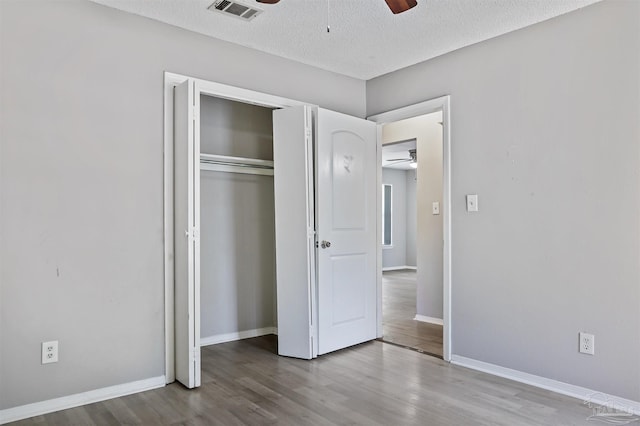 2811 Langley Ave Unit 221, Pensacola, FL 32504 - unfurnished bedroom with wood finished floors, a closet, a textured ceiling, baseboards, and ceiling fan
