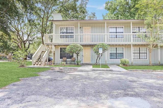 2811 Langley Ave Unit 221, Pensacola, FL 32504 - view of front of house with a chimney, stairway, a front lawn, and covered porch