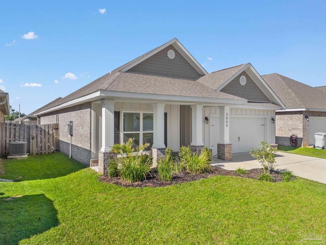 view of front facade featuring cooling unit, a garage, and a front lawn