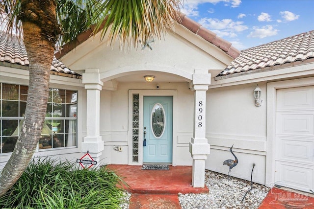 8908 Cutter Ct, Navarre, FL 32566 - property entrance with a tile roof, stucco siding, and covered porch