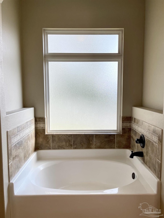 bathroom with a wealth of natural light and a bath