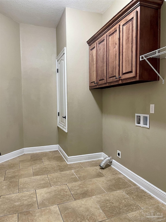 washroom featuring hookup for an electric dryer, a textured ceiling, baseboards, hookup for a washing machine, and cabinet space