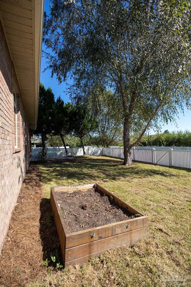 view of yard with a fenced backyard and a garden