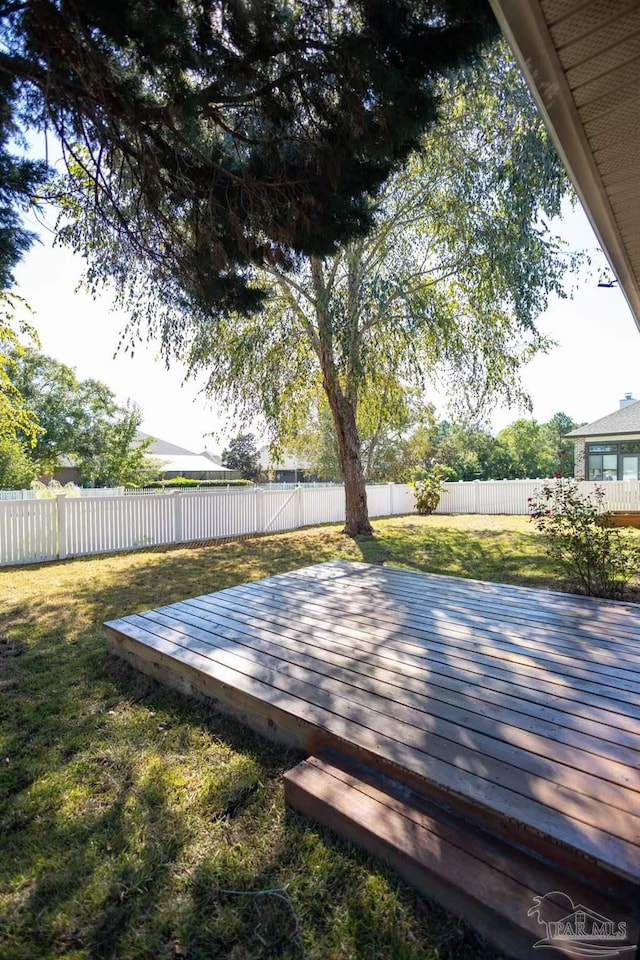 wooden deck with a fenced backyard and a yard