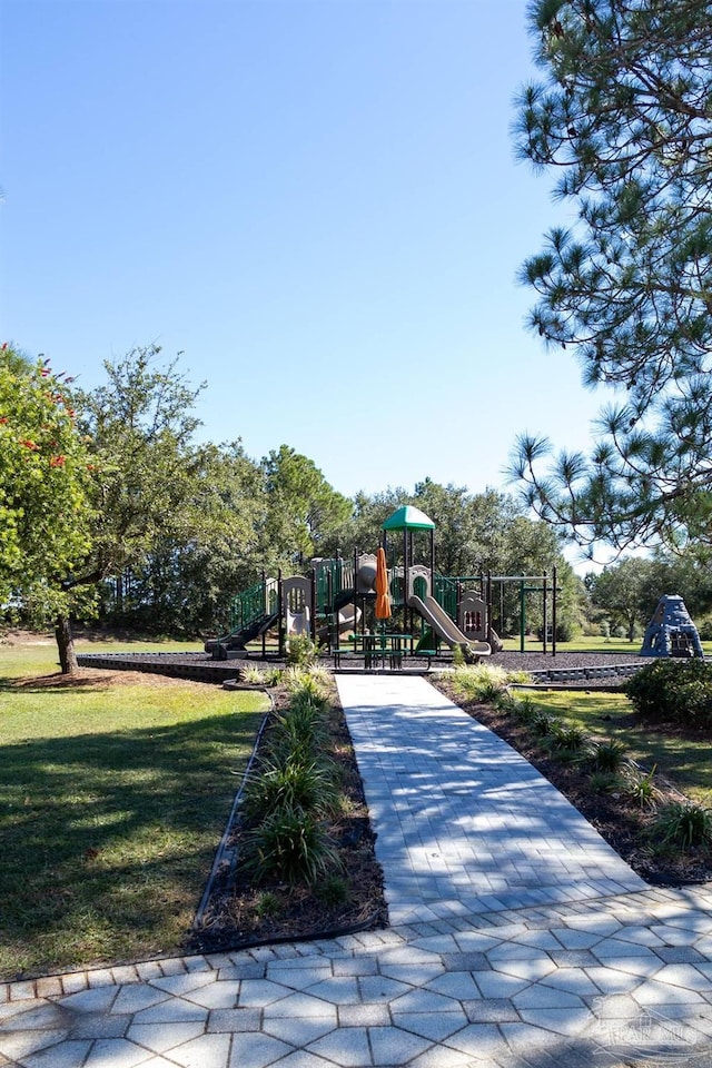 view of property's community featuring playground community and a yard