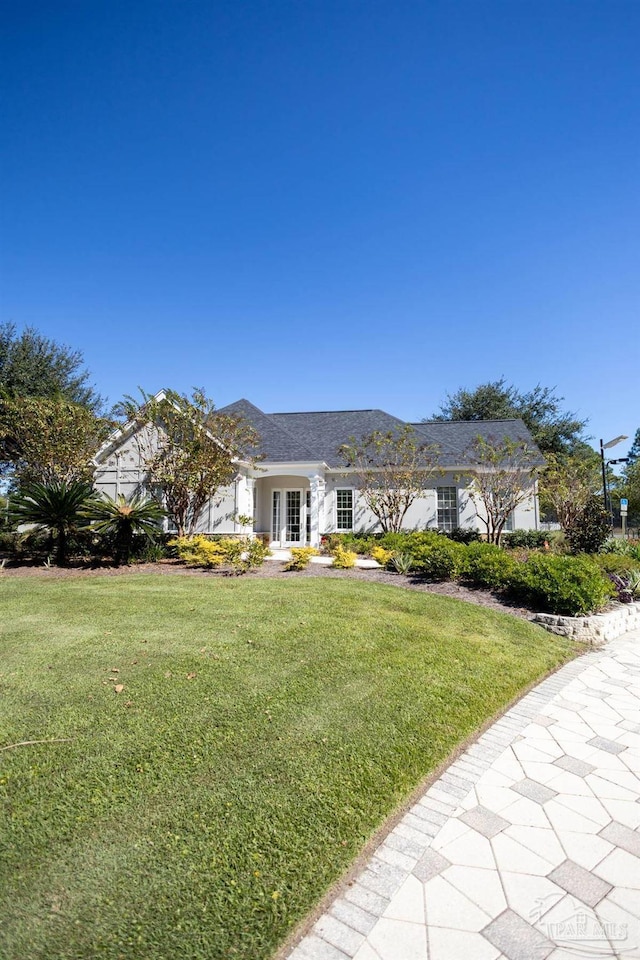 ranch-style home featuring french doors and a front lawn