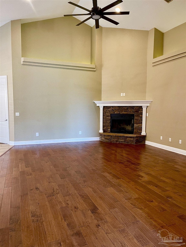 unfurnished living room with a fireplace, a ceiling fan, hardwood / wood-style floors, and baseboards