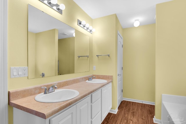 208 Millet Cir, Cantonment, FL 32533 - bathroom with wood finished floors, a tub to relax in, double vanity, and a sink