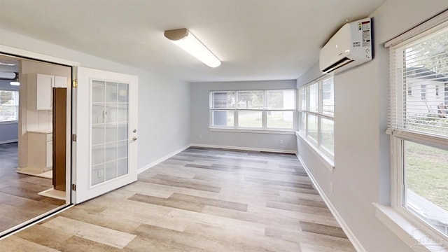 interior space with a healthy amount of sunlight and an AC wall unit