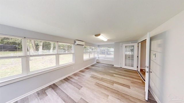 unfurnished sunroom with a wall unit AC