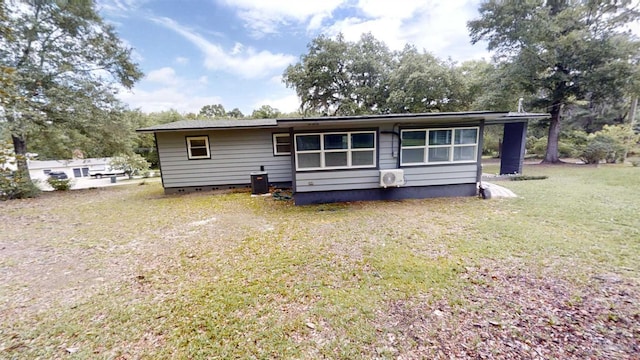 rear view of property with a lawn and cooling unit