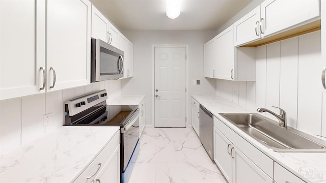 kitchen with white cabinets, backsplash, stainless steel appliances, and sink