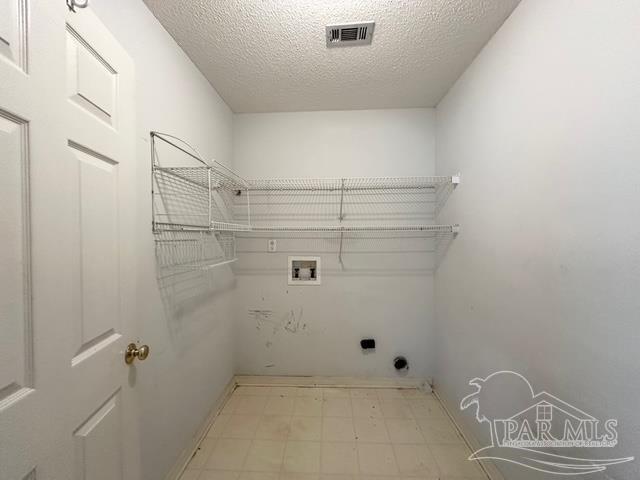 5473 Timber Creek Cir, Pace, FL 32571 - laundry room featuring tile patterned floors, washer hookup, a textured ceiling, and electric dryer hookup