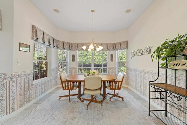 tiled dining area featuring a towering ceiling and a notable chandelier