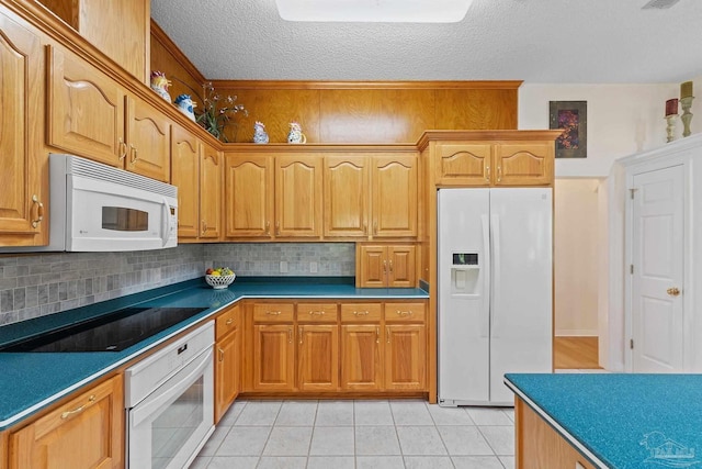 kitchen featuring a textured ceiling, decorative backsplash, light tile patterned floors, and white appliances