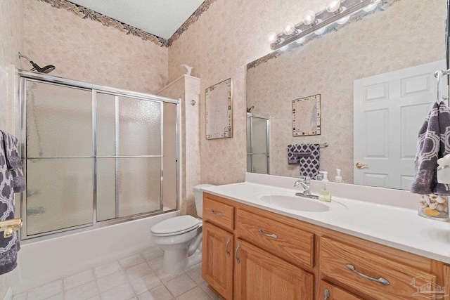 full bathroom featuring vanity, shower / bath combination with glass door, tile patterned flooring, toilet, and a textured ceiling