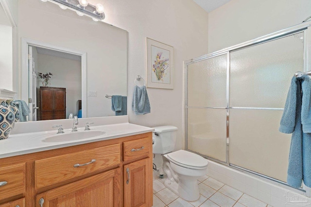 bathroom featuring tile patterned flooring, vanity, toilet, and a shower with shower door