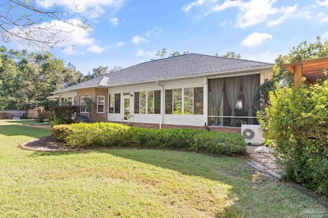 rear view of property with a yard, a sunroom, and ac unit